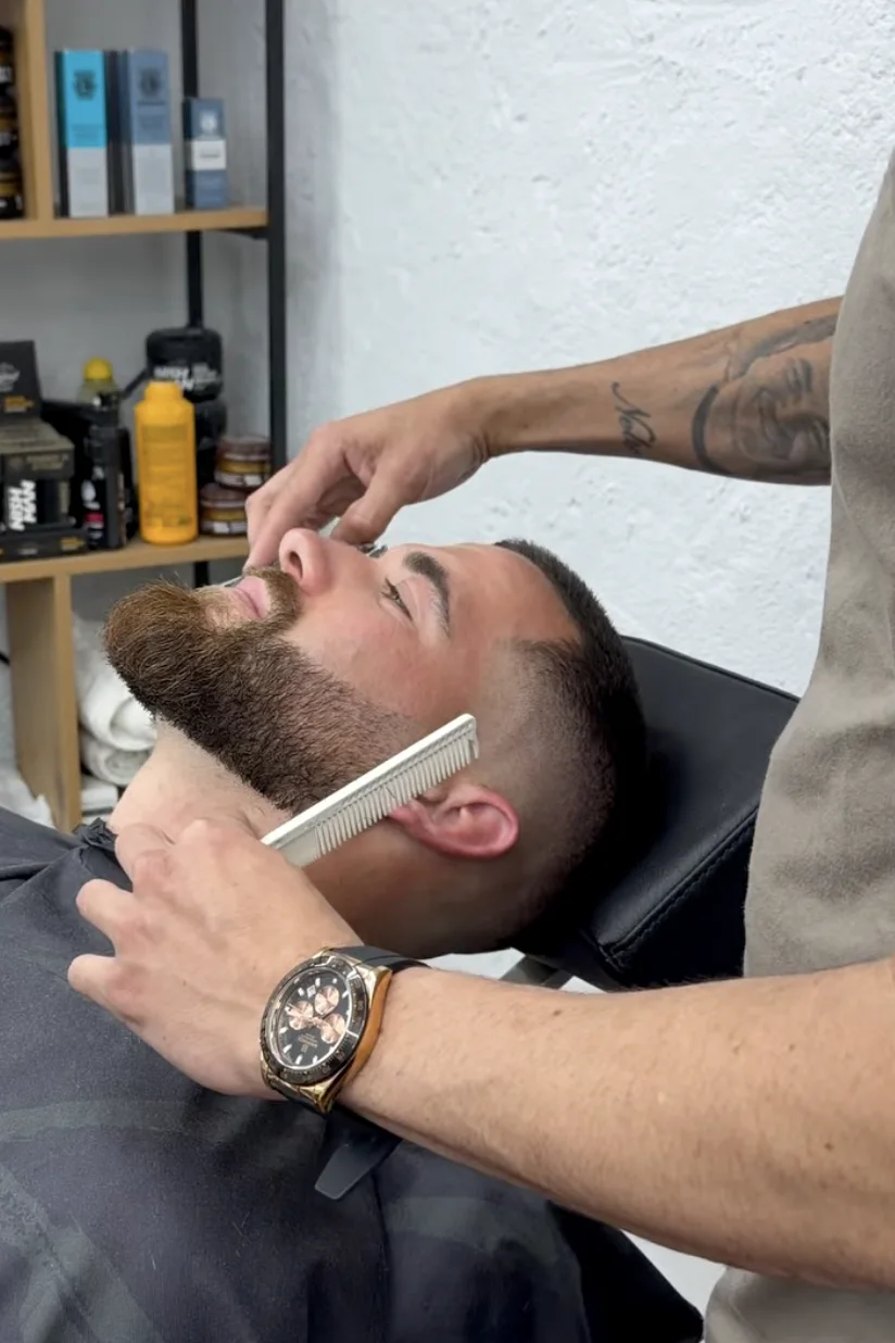 Barbeiro a aparar a barba de um cliente no Nielson Barber Studio
